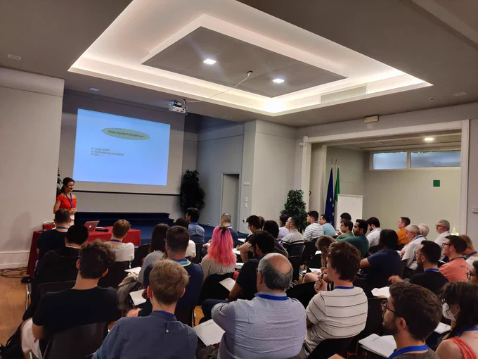 Alexandra Jimborean giving a lecture to a full room at ACACES 2022