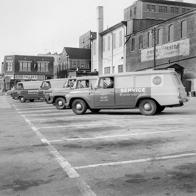 Photograph of a row of parked Sears service vehicles, 1964. Caption: Sears-Roebuck Service Department, 907 Purchase Street, New Bedford.