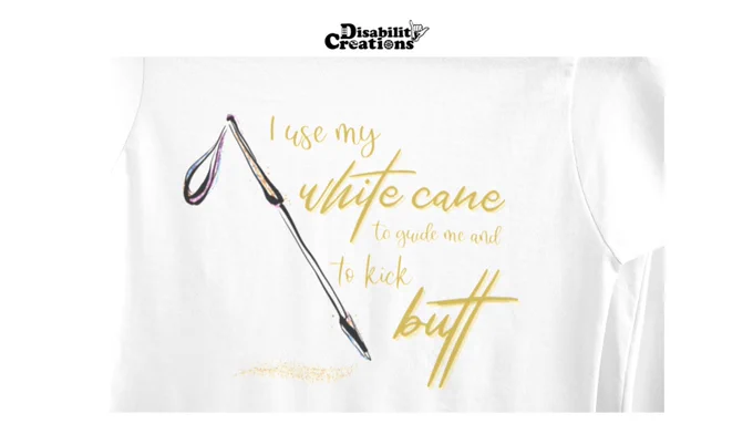 T-shirt Description: A white shirt that has a white cane. The cane has tints of blue, pink, and gold. There is a golden path on the ground where the cane tip touched. On the right, it says I Use My White Cane to Guide Me and to Kick Butt in gold! ⁠
⁠
Image Description: A close-up of the shirt.