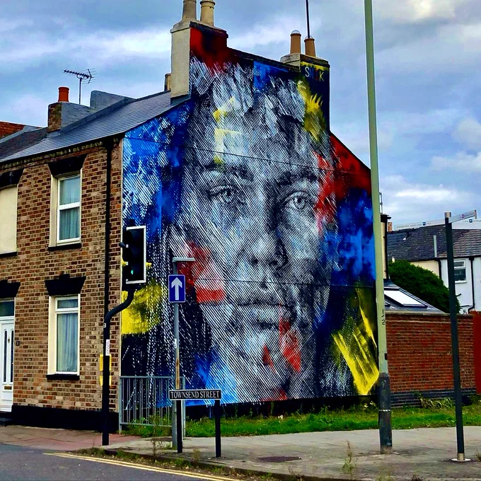 street art by @snikarts of a sketched face with colours dotted around
