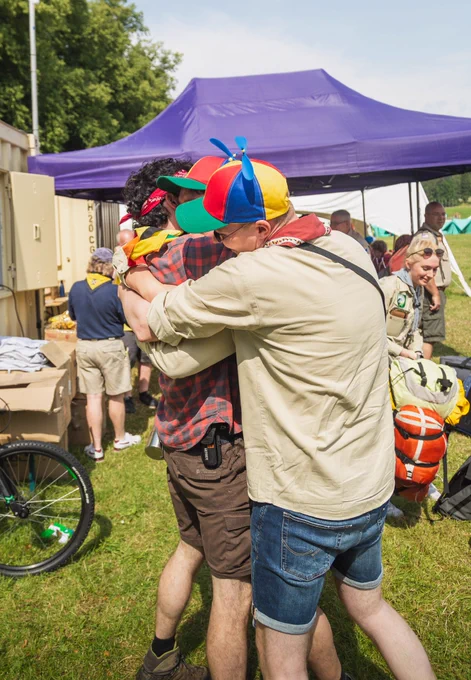 Three young people embracing after being reunited at an international Scouting event