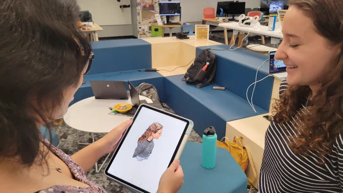 After 3D scanning one another, two students look over their work together
