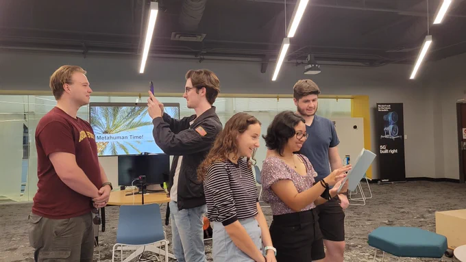 Students gathered in a classroom, engaged in phone and tablet-based 3D scanning