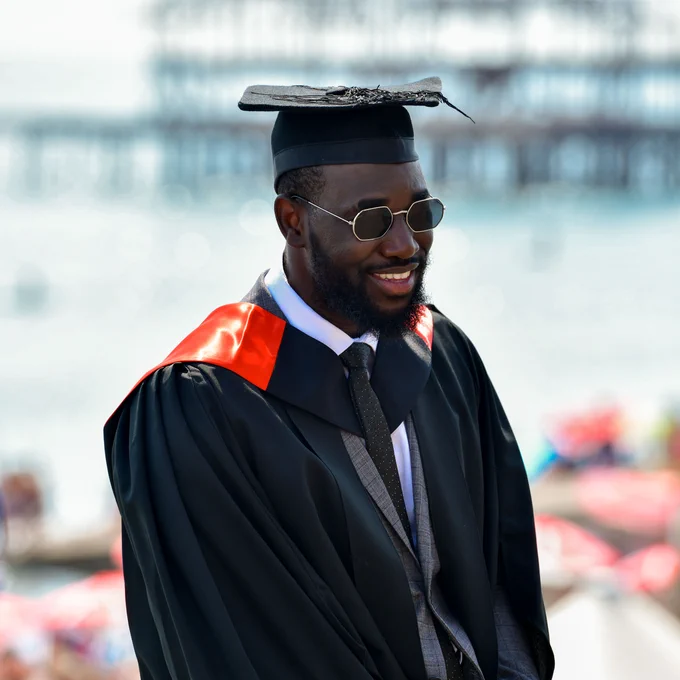 a grad smiles in front of West Pier