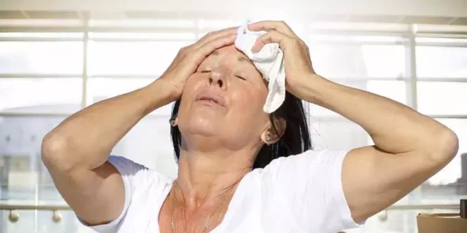 Lady trying to cool down with a wet flannel
