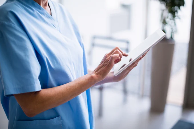 A healthcare professional using a tablet.