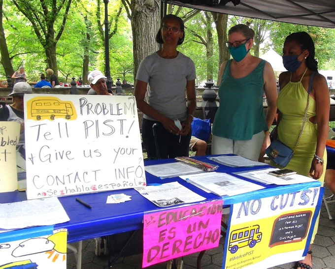 Background: trees. Middle ground: 2 Puerto Rican activists sit on a bench, 1 woman with Diabetes and 1 Blind man. Front: 1 Dominican woman, 1 white woman and 1 African american woman are standing by a table that has informational flyers. The table is decorated with a blue tablecloth and signs with images of yellow school buses. Text of the nearest signs read "School Bus Problem? Tell PIST & give us your contact info. Se habla espanol"; "La Educacion es un Derecho"; "No Cuts! #WeArePIST Parents to Improve School Transportation, Educational Access for ALL is a Human Right and a Civil Right."