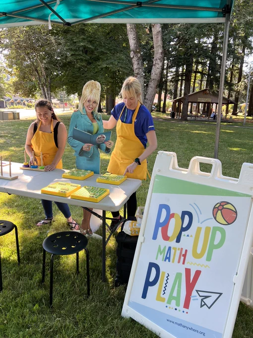 Dolly Parton cutout playing with mathematical toys in the park.