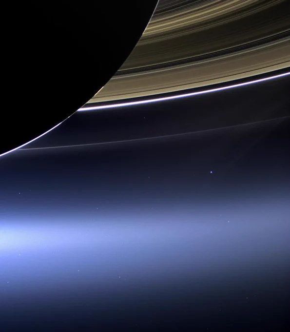 An image taken from the Saturnian system shows the ringed planet in the foreground and in the dark blue space Earth is a bright dot just below the beautiful rings.