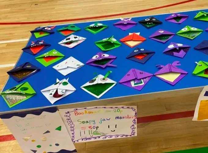 'Snappy monsters' made of paper and laid out on a blue tablecloth.