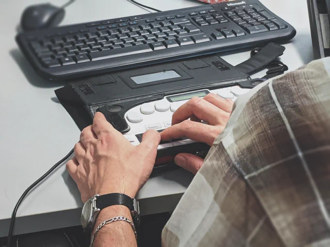 A person working on a Braille laptop.