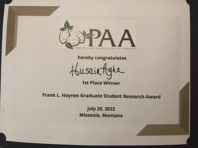 Certificate reading "The Potato Association of America hereby congratulates Husain Agha, 1st place winner, Frank L. Haynes Graduate Student Research Award July 20, 2022 Missoula, Montana." Has the Potato Association logo, consisting of some graphical representation of potatoes and PAA in large font.
