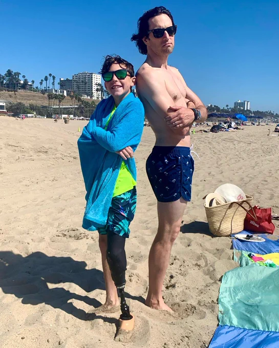 Boy and one legged man on beach
