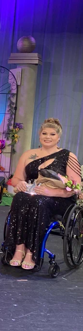 Holding her flowers and award