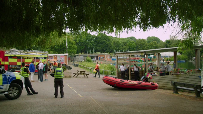 What3Words event at Stanborough Lakes. Firefighters and Police pictured standing with lake in background.