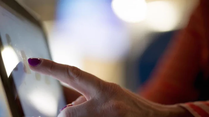 Hand swiping on an iPad with data and analytic information
