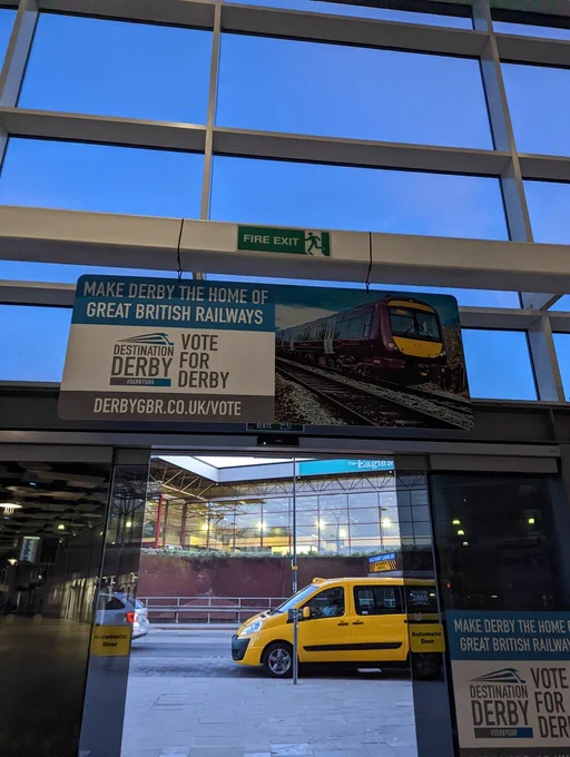 Vote for Derby GBR hanging above door out of bus station.