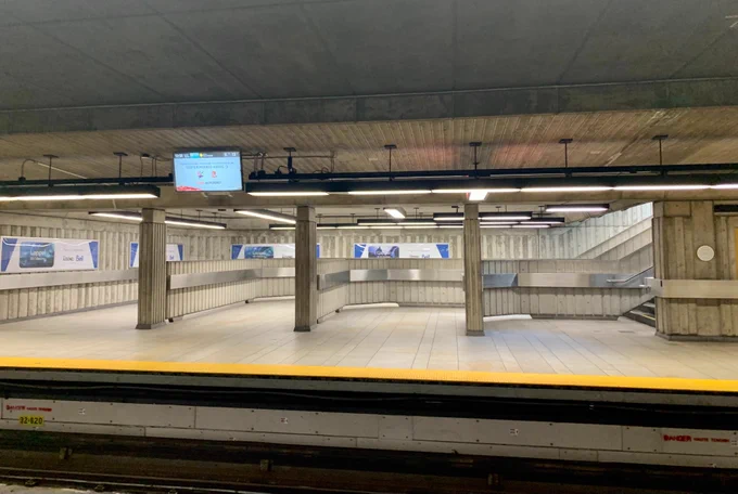 Staircases on opposite side of metro platform. Each features an extended wall so that the user has to choose a single lane before walking on a staircase