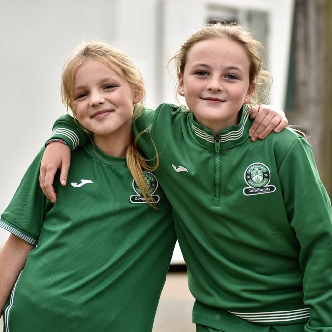 Two young Girls Academy players watch Hibs Women train at HTC.
