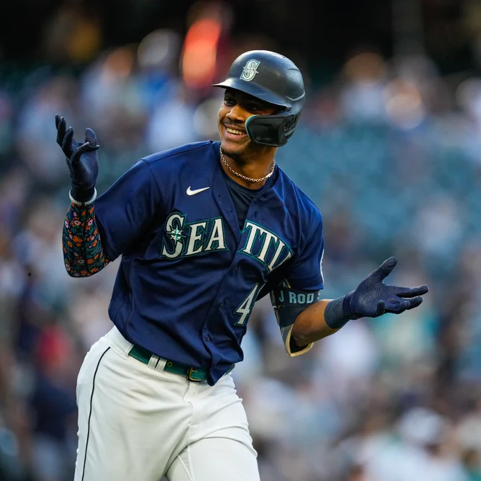 Julio Rodríguez smiles and shrugs after hitting a home run.