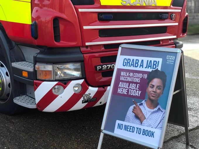 Solent NHS Trust poster in front of a fire engine 

'Grab A Jab - Walk-in Covid-19 vaccinations available here today - no need to book'