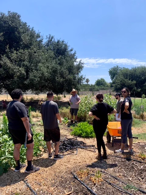 Farmer Stephen of Lopez Urban Farm education Cal Poly Pomona marketing students about how a community can feed itself. 