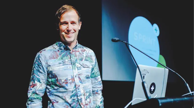 photo of Dan Burka at a lecturn smiling at a camera