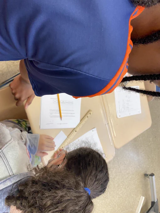 Students measuring an index card with a ruler.