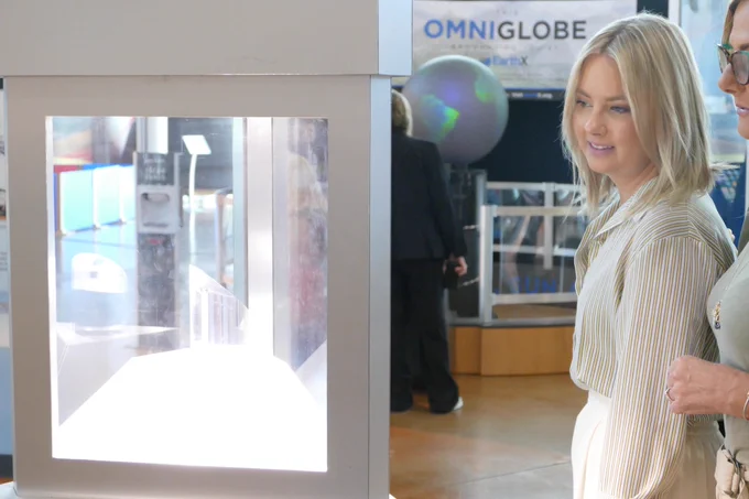A woman smiles as she looks at a display
