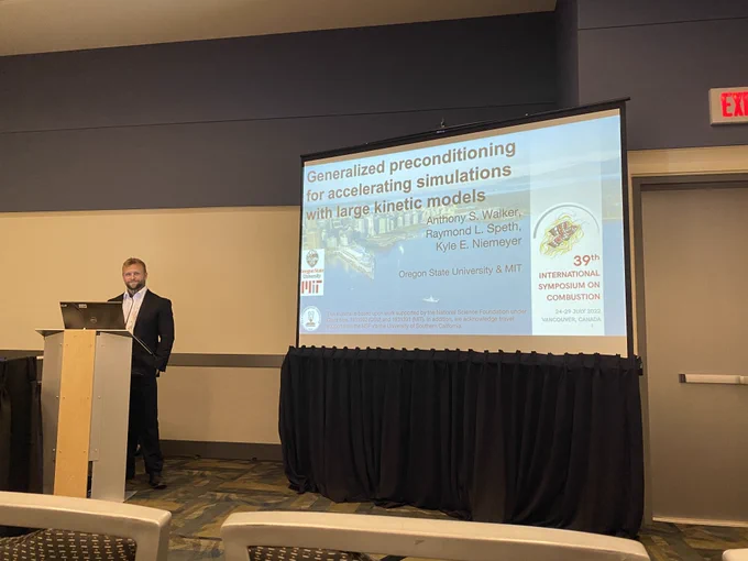 Man standing and smiling in front of a research presentation