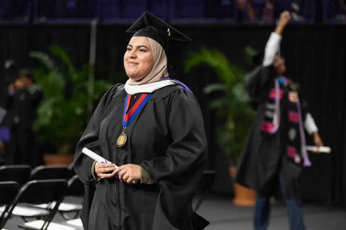 A graduate smiles after walking across the stage at Clemson graduation. 