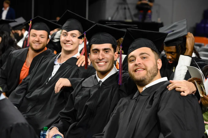 A group of graduates smiles during Clemson graduation. 