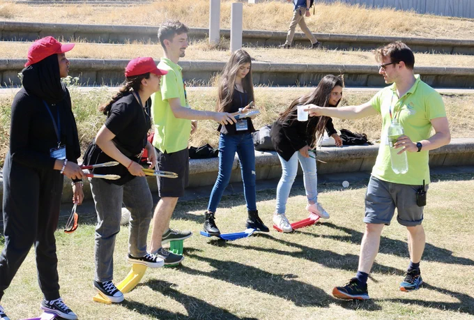 The young people balancing on the skateboards doing an activity about deep space