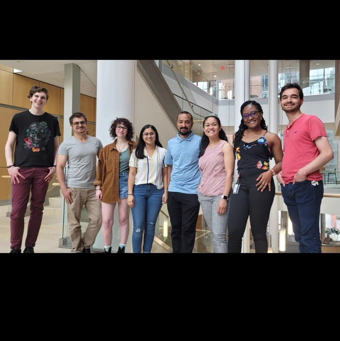 An official photo of the lab members of the deredge lab, all smiling at the camera. 