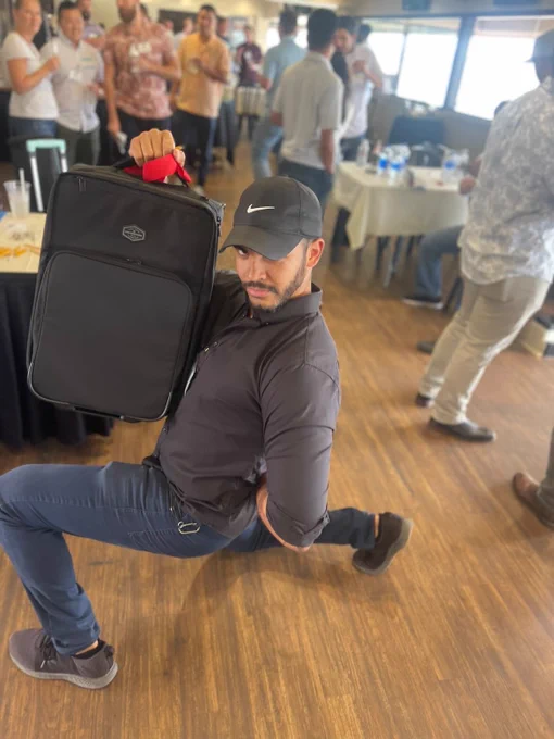 A customer making a comically deep lunge to show off their giveaway prize (a new rolling suitcase).