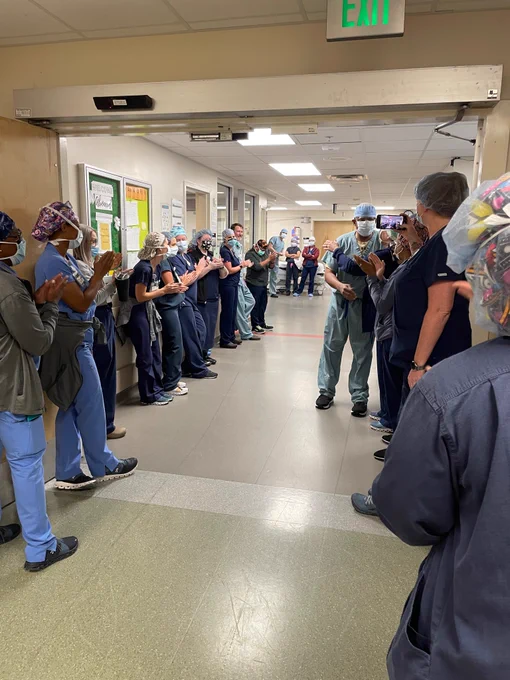 Dr. Vickers walking down hall of colleagues applauding after he finished his last case at UAB
