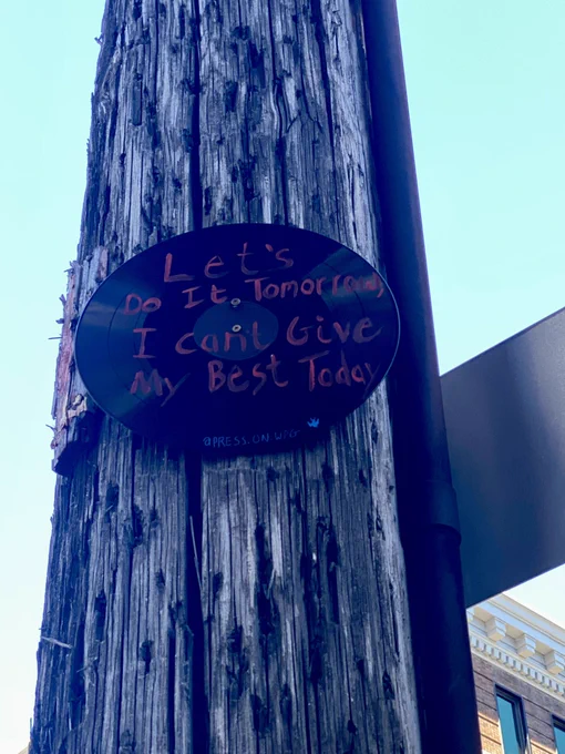 L.P. Attached to a hydro pole and written on it is “Let’s do ut tomorrow, I can’t give my best today” in red paint.