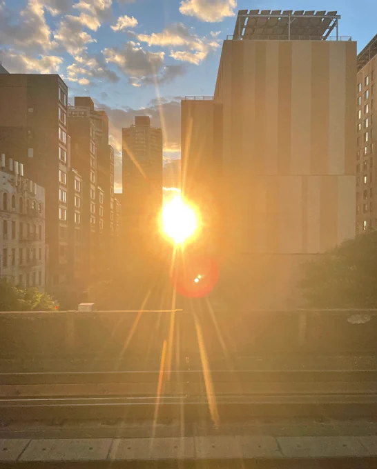 The sun shining between buildings in East Harlem, New York City.