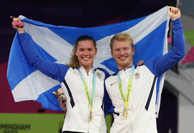 Commonwealth Games gold medallists Grace Reid and James Heatly holding a Scotland flag