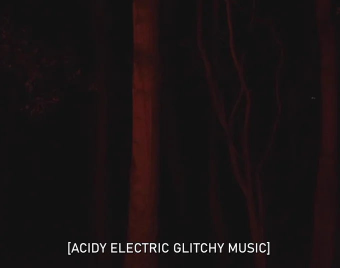 A still from The Commons showing a dark mysterious part of the forest, in shades of red and black, with the caption: "ACIDY ELECTRIC GLITCHY MUSIC."