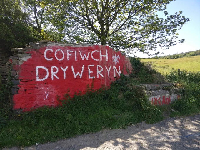 A photo of the 'Cofiwch Dryweryn' wall in Ceredigion. The Welsh words 'Cofiwch Dryweryn' are written in white on red paint. It means 'Remember Tryweryn' in English. 