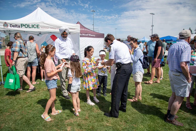 Chief Neil Dubord handing out popsicles to children at the Tsawwassen Sun Festival. 