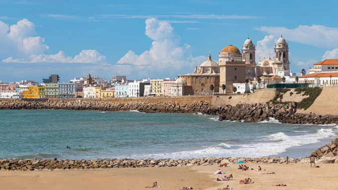 Photo of Cadiz, Spain showing the beach in the foreground and the city skyline in the background. 