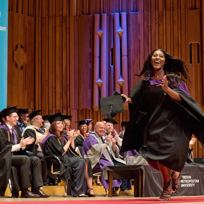 Graduate smiling whilst walking across stage