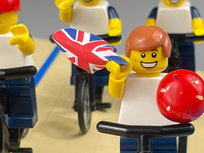 Close up on lego Ed Clancy on a bike waving a GB flag and a red helmet 