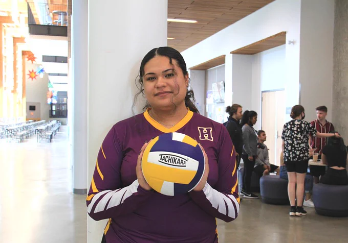 Student holding volleyball in commons area