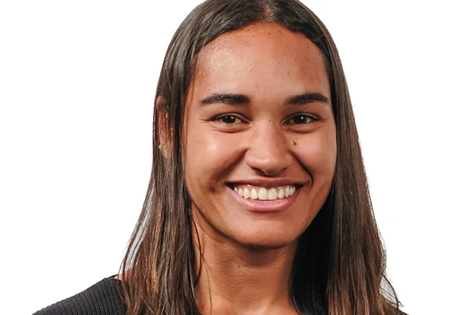 A headshot of Noemie Midrez, a young woman with brown skin and long brown hair, smiling at the camera.