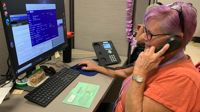 A photo of an election worker curing signatures. 
