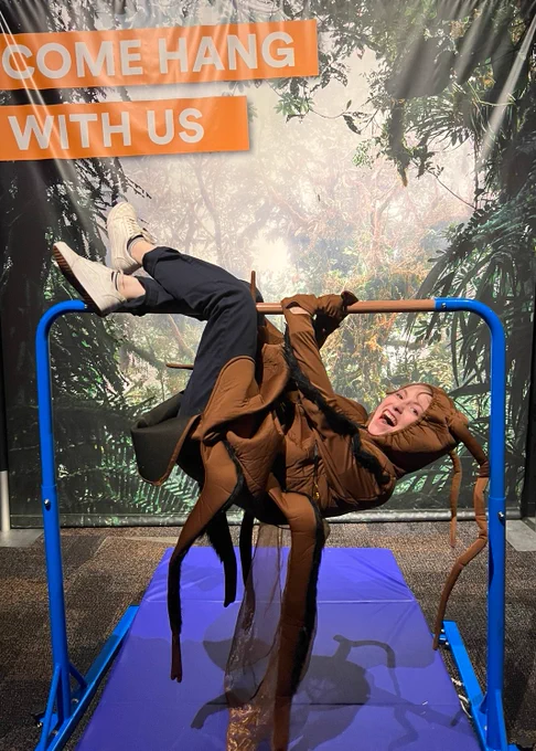 Girl in a cockroach costume hanging upside down