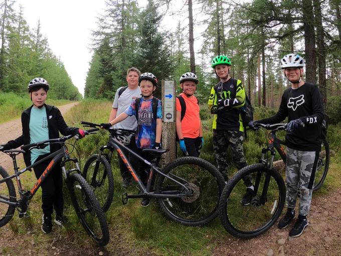 A group of young people on a woodland mountain bike session stop for a photo... and a quick break. 